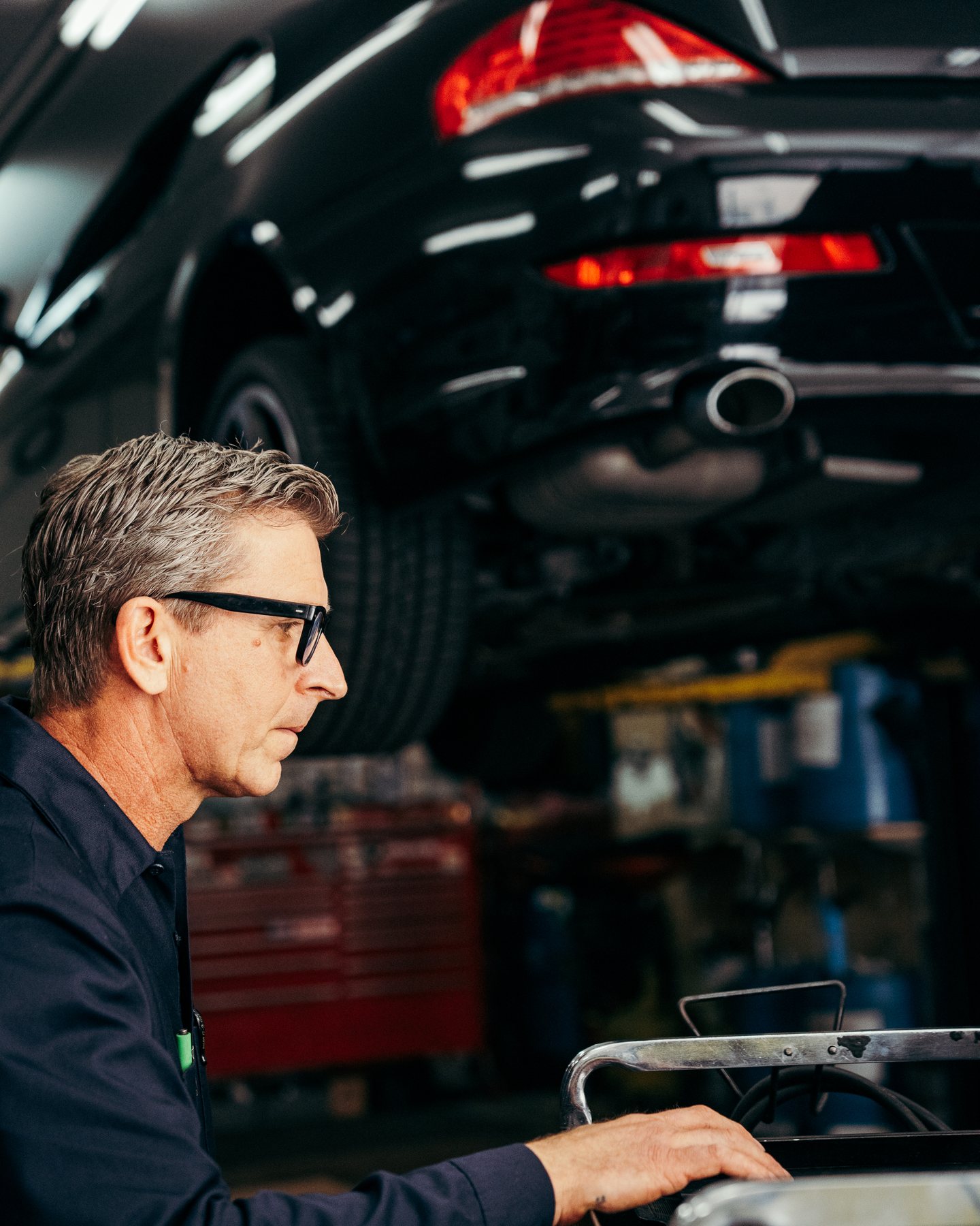 Luke Bennett using a diagnostic laptop behind a vehicle