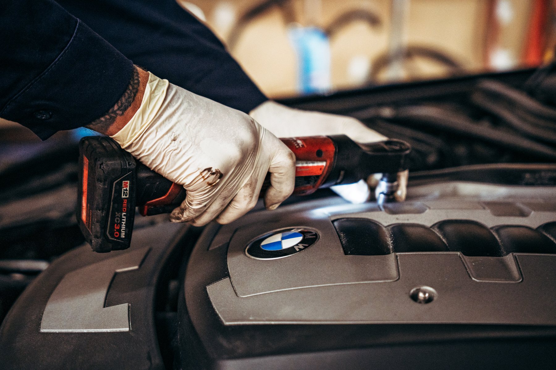 Hands working in a BMW engine bay