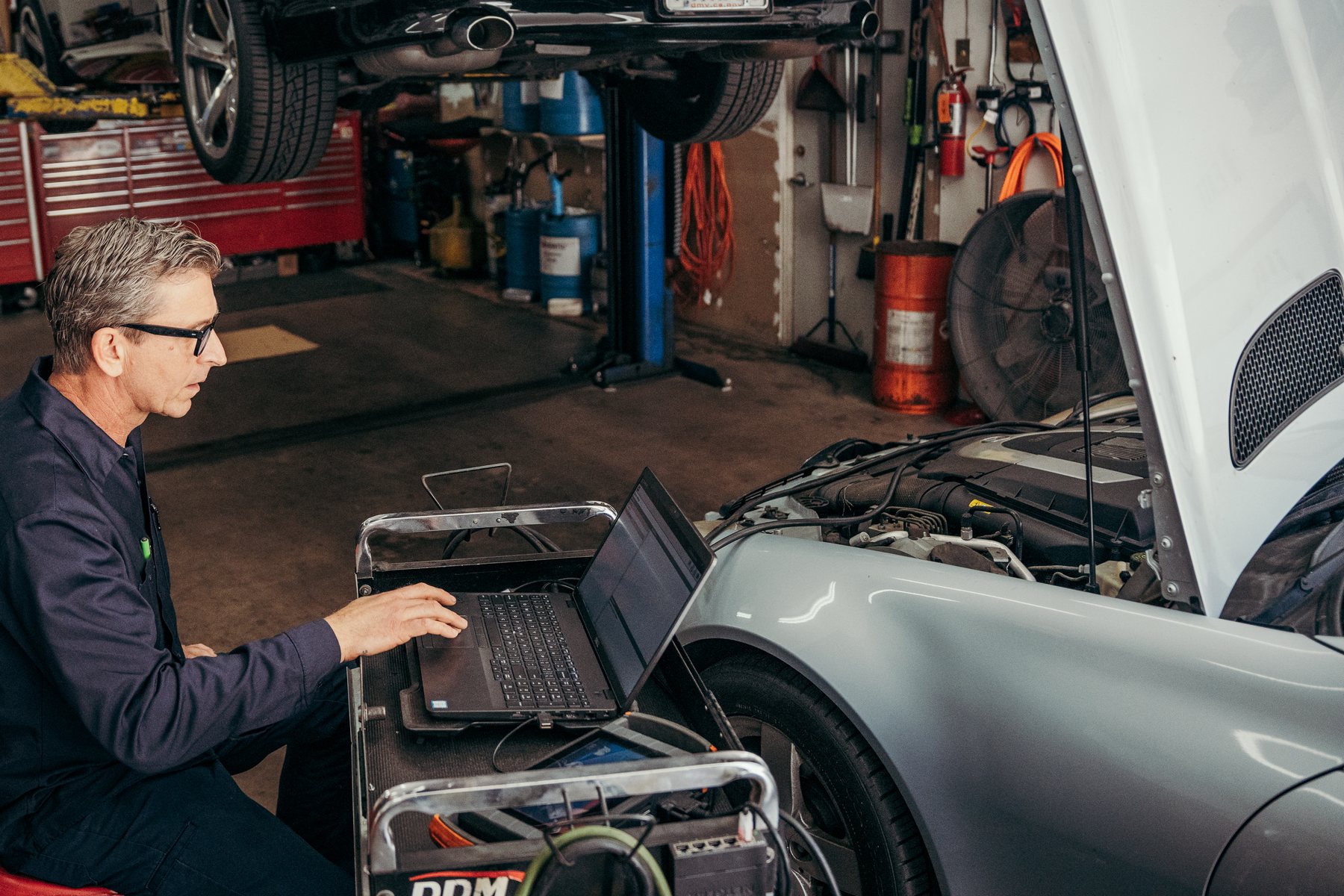 Diagnostic laptop beside an engine bay