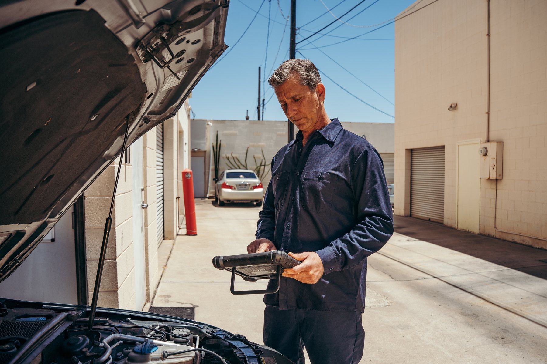 Luke Bennett inspecting a vehicle outside the shop
